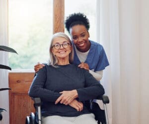 A woman in a wheelchair with another person.